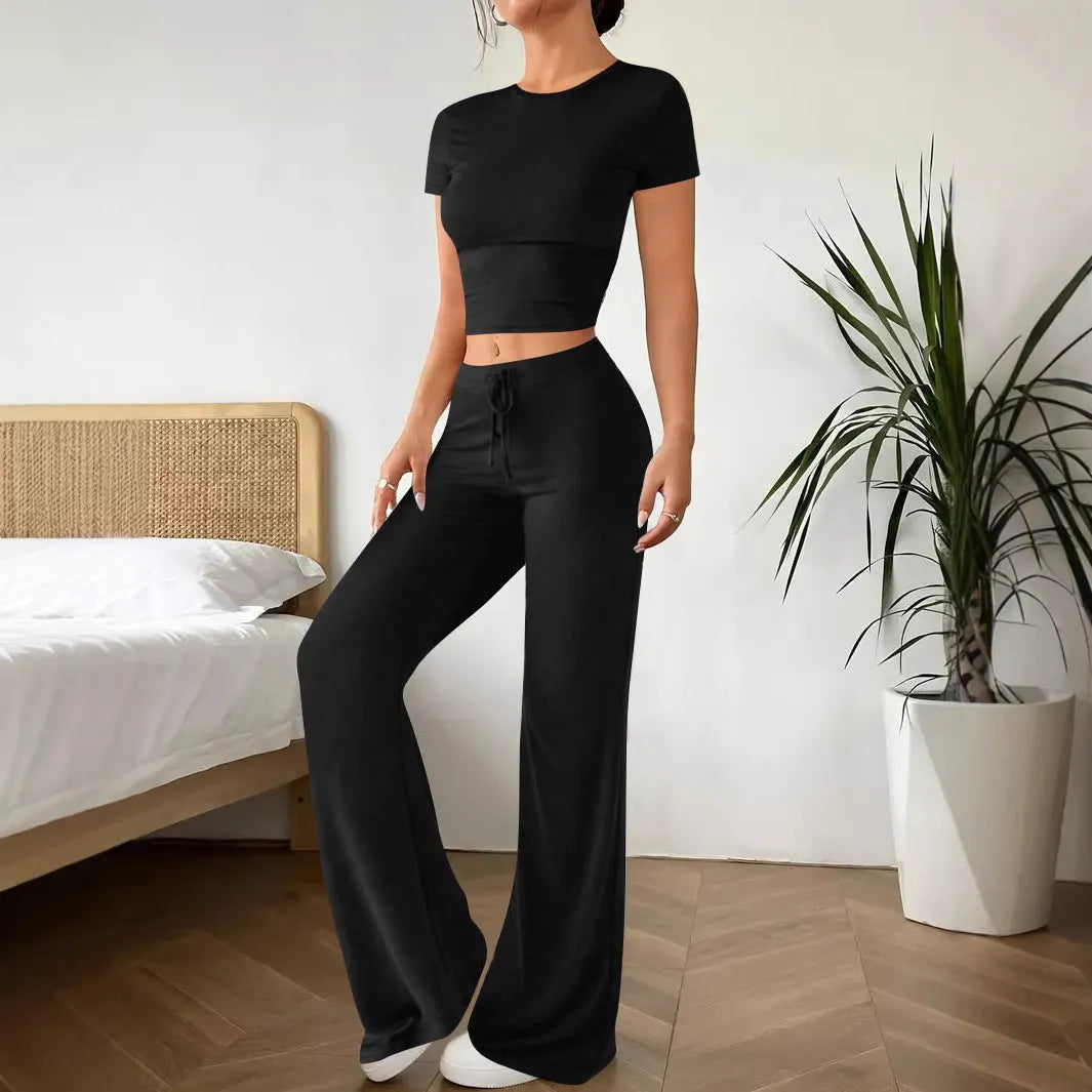 Black women's polyester trousers suit with high-waist trousers and a short-sleeve T-shirt on a hanger.