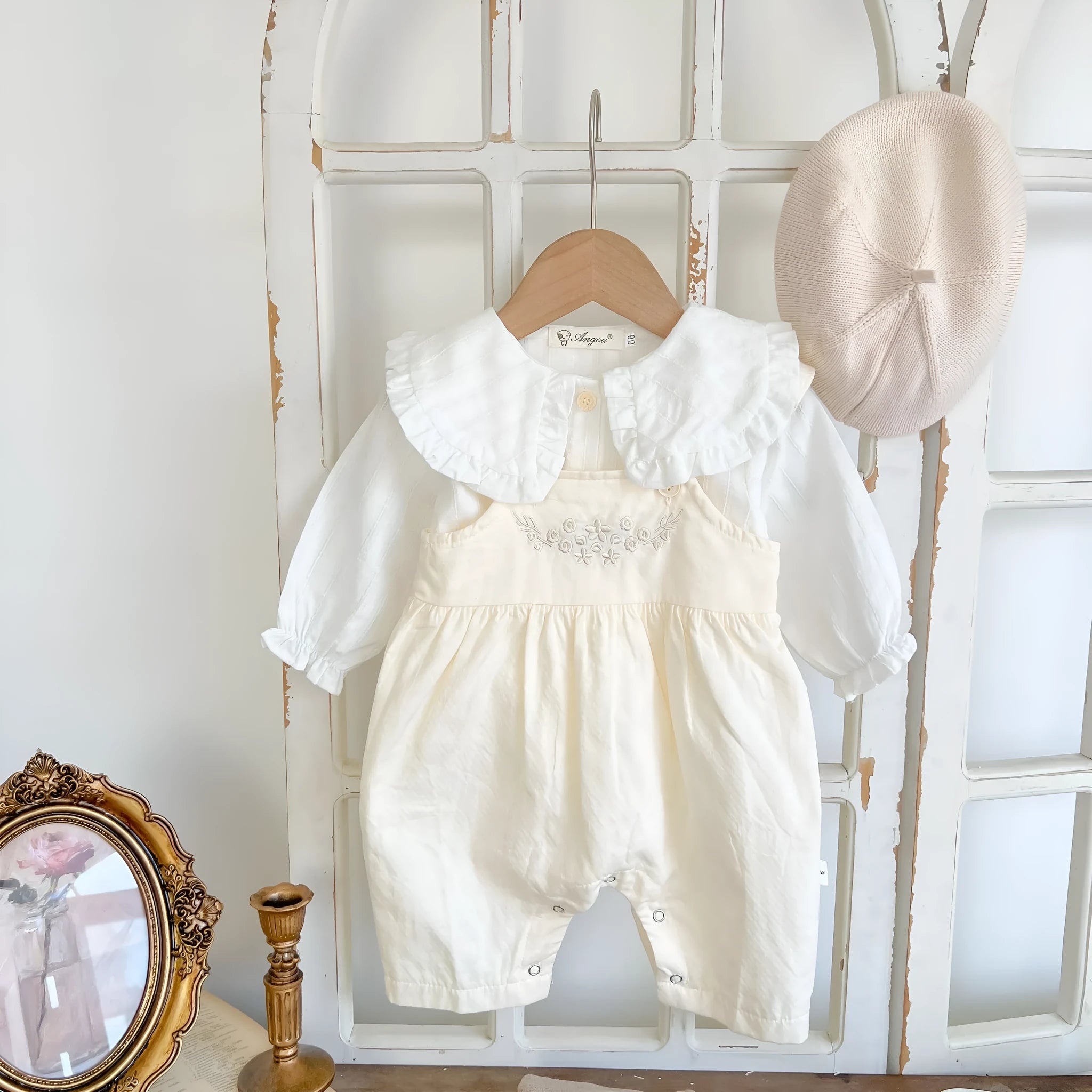 Apricot coloured baby girl's cotton romper with white top, adjustable suspenders, and mid-waist trousers.