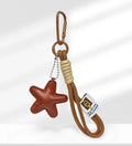 Handmade brown bread design bag pendant with a cartoon croissant on a brown strap.