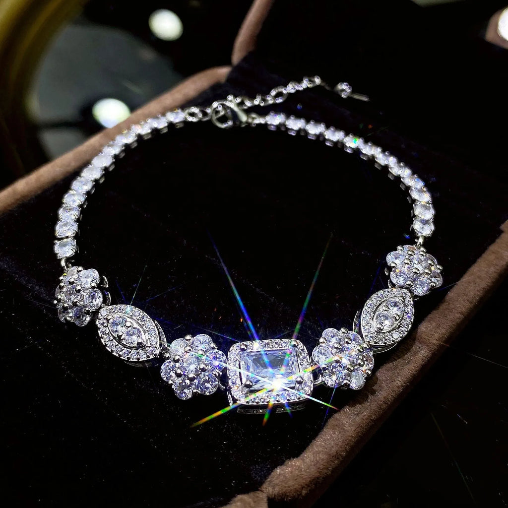 Close-up of women's geometric silver bracelet with sparkling cubic zirconia stones on a wrist, showing adjustable clasp.