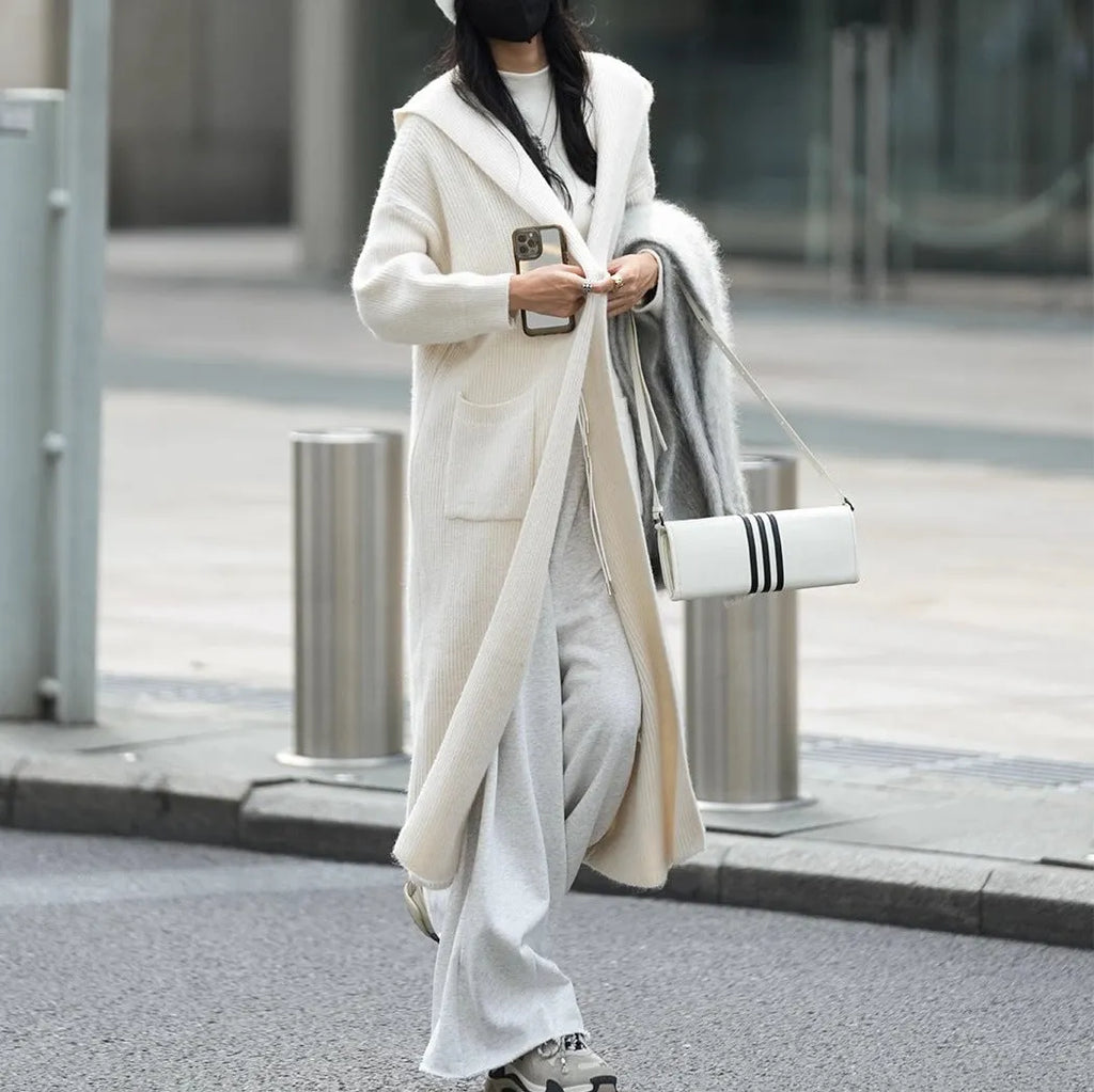 Long grey hooded cardigan sweater with a trench coat style, made from a wool and cashmere blend.