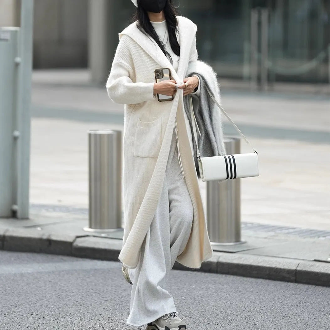 Long grey hooded cardigan sweater with a trench coat style, made from a wool and cashmere blend.