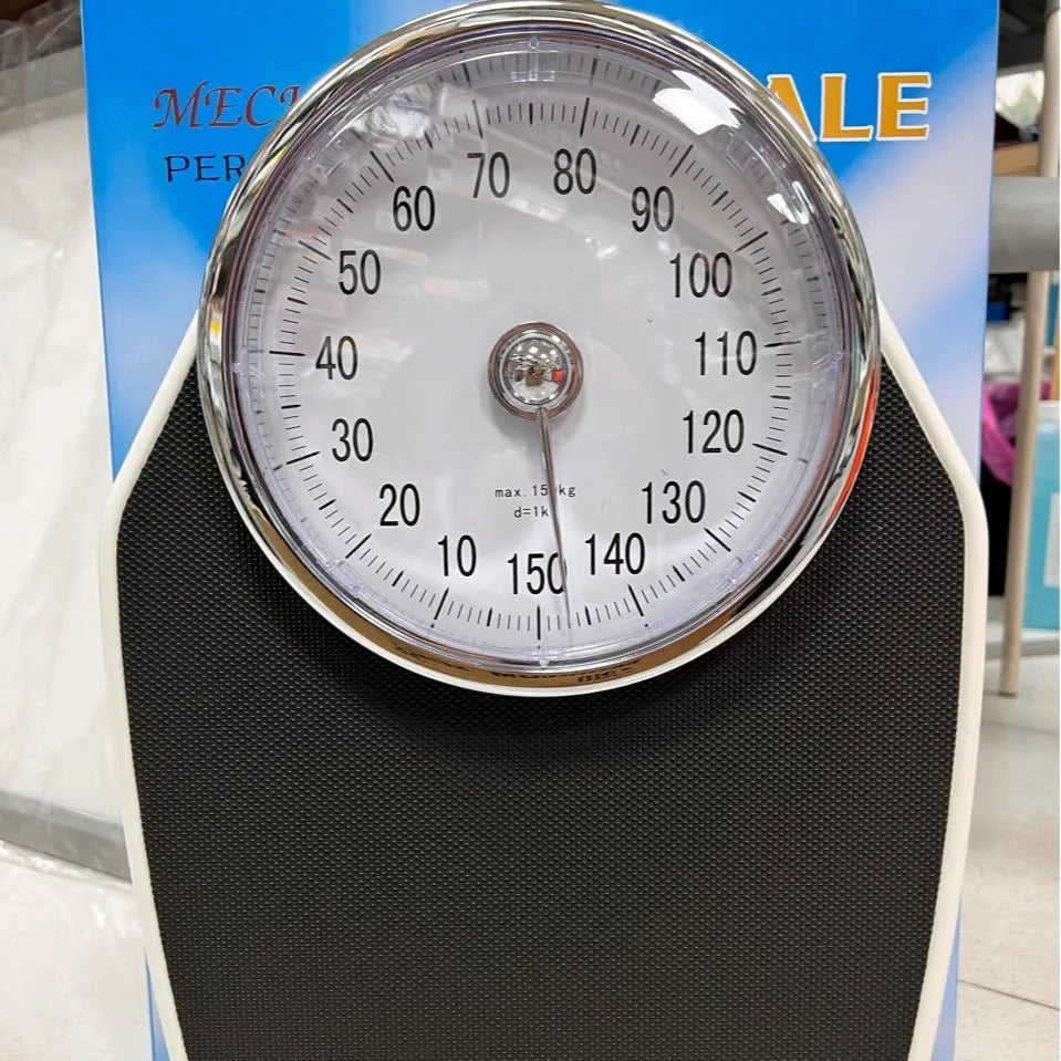 Black mechanical pointer bathroom scale on floor showing large dial and 47x35cm platform.