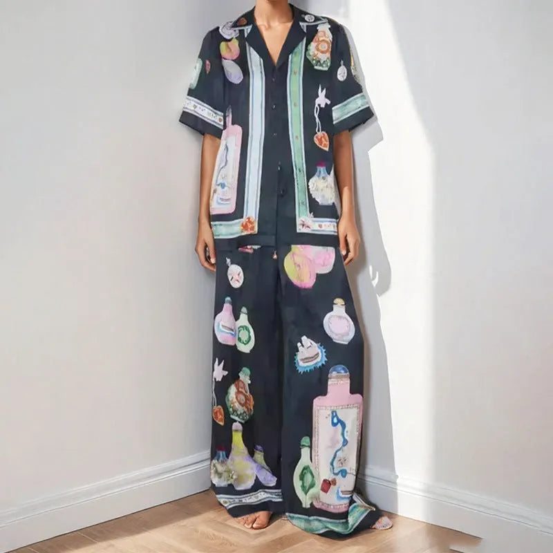 Black women's casual set with cartoon print, featuring a cardigan and matching trousers on a hanger.
