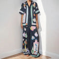 Black women's casual set with cartoon print, featuring a cardigan and matching trousers on a hanger.
