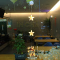 Set of three Christmas LED light pendants with suction cups, showing star, deer, and tree designs on a window.