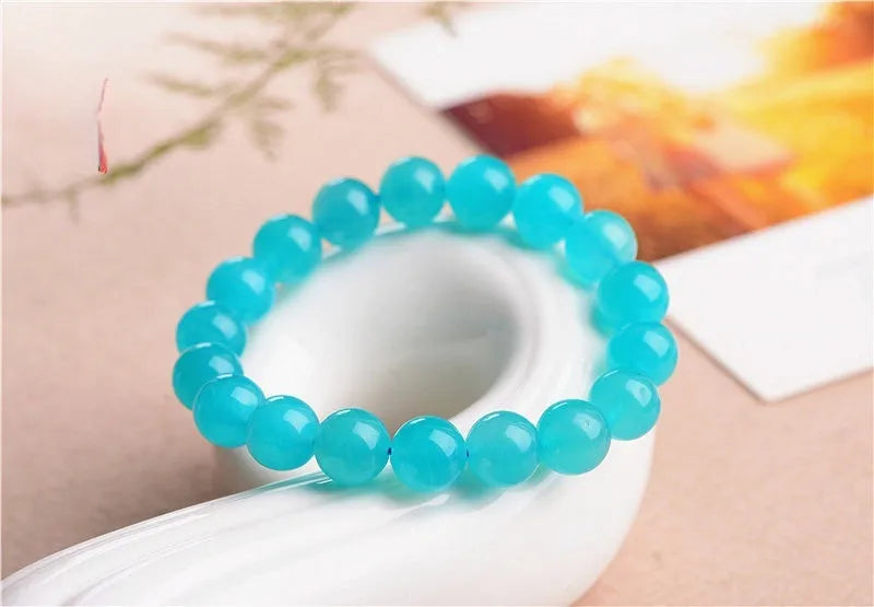 Loose natural green Amazonite beads in various sizes for jewellery making on a white surface.