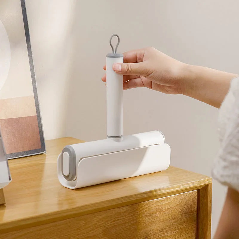 Handheld pet hair lint roller with a sticky paper surface on a yellow core.