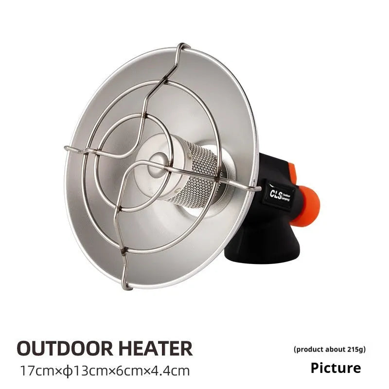 Black and orange portable camping stove with automatic ignition on a rocky outdoor surface.