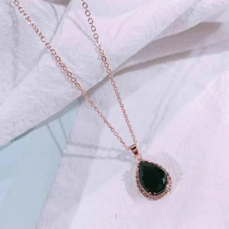 Rose gold water drop shaped necklace with geometric design and rhinestone accents in pink colour