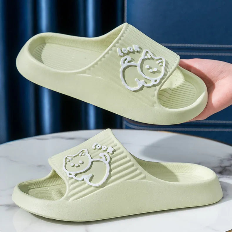 Women's green cat-themed platform slippers with non-slip EVA sole on a wooden floor.