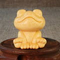 Solid bamboo carving of a smiling cartoon frog ornament, 5cm tall.
