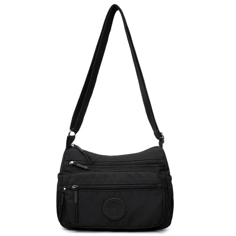 Water-repellent nylon crossbody bag in grey, showing front 3D pocket and single strap.