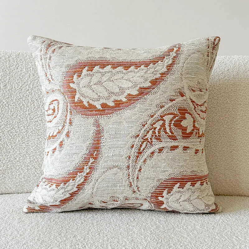American-style jacquard paisley pattern sofa cushion cover in an amber colour on a grey sofa.