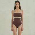 Brown women's one-piece triangle swimsuit on a hanger, showing nylon fabric texture.