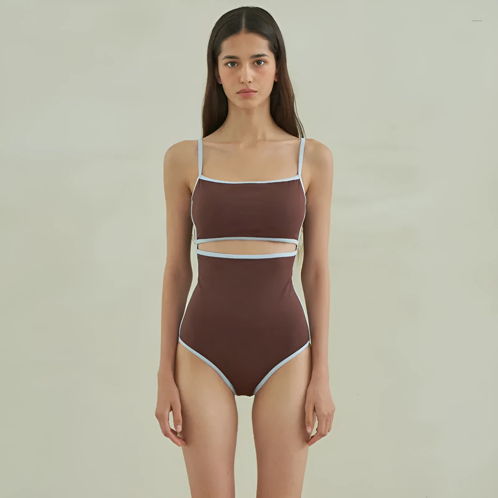 Brown women's one-piece triangle swimsuit on a hanger, showing nylon fabric texture.