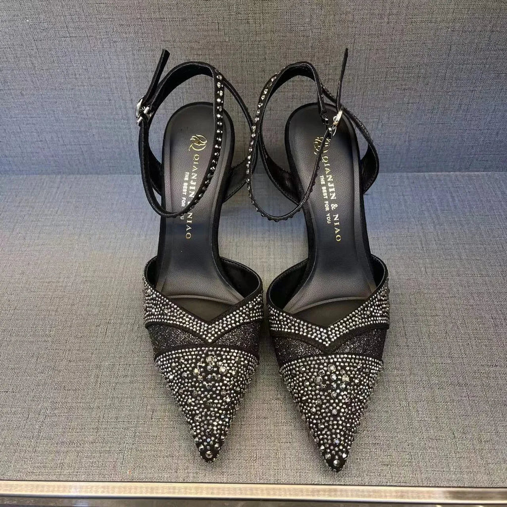 Women's black pointed-toe stiletto heels with a hollow-out design and red sole.