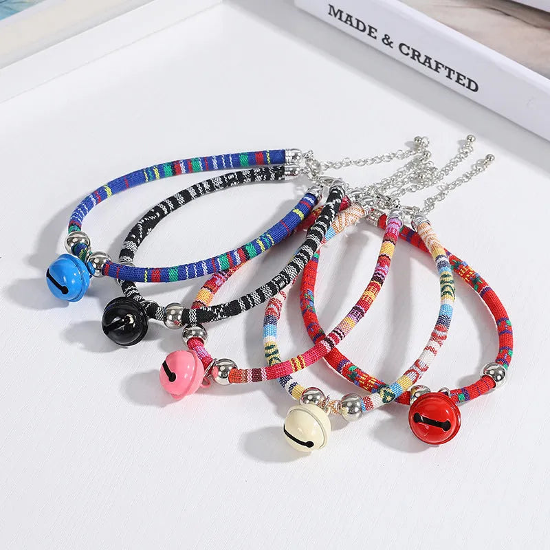 Adjustable ethnic-pattern pet collar with metal bell in blue, showing buckle and size tag.