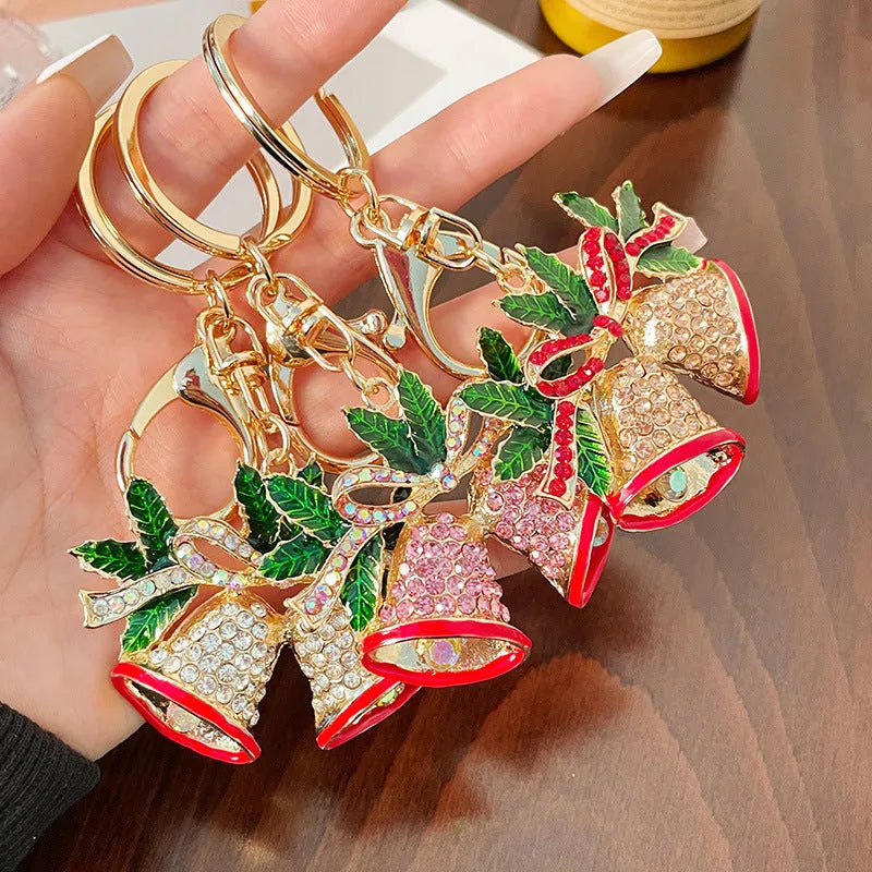 Diamond studded metal Christmas bell keychain in European style on a white background