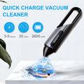 Black wireless handheld car vacuum cleaner with brush and flat attachments on a car seat.