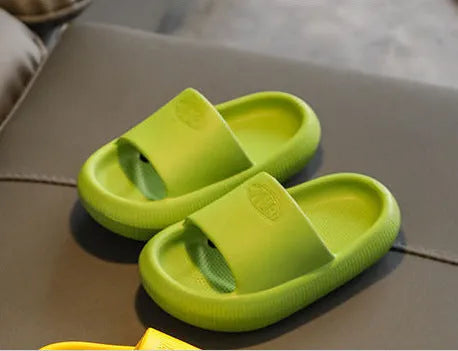 Colourful children's EVA slippers with textured non-slip sole, shown in blue, green, orange, pink, and yellow.