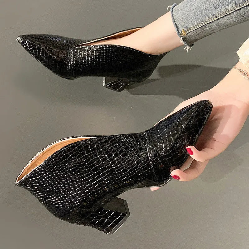 Women's black V-cut pointed toe Martin boots with embossed detail and a chunky heel.