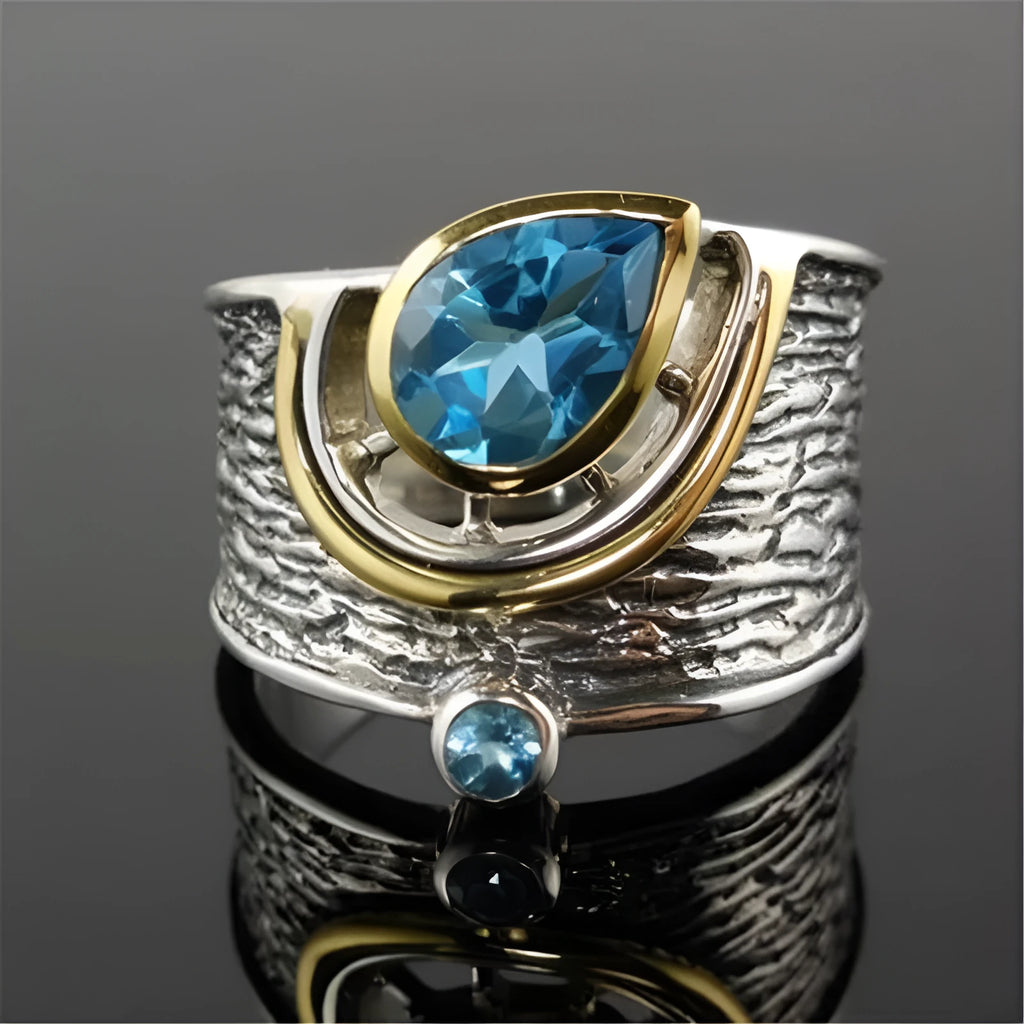 Blue drop-shaped zircon ring with Chinese-style design on a model finger.