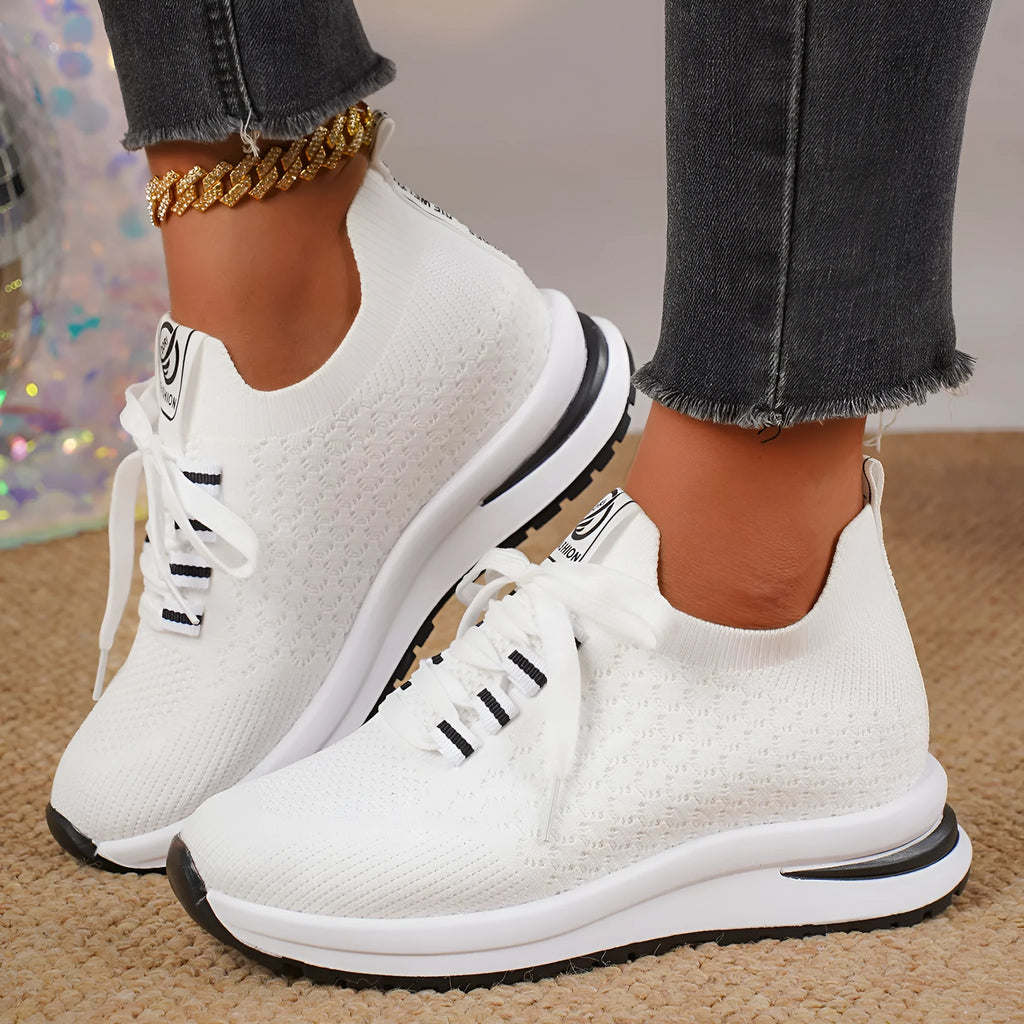 Women's black and white mesh platform sneakers with flat sole and lace-up front.