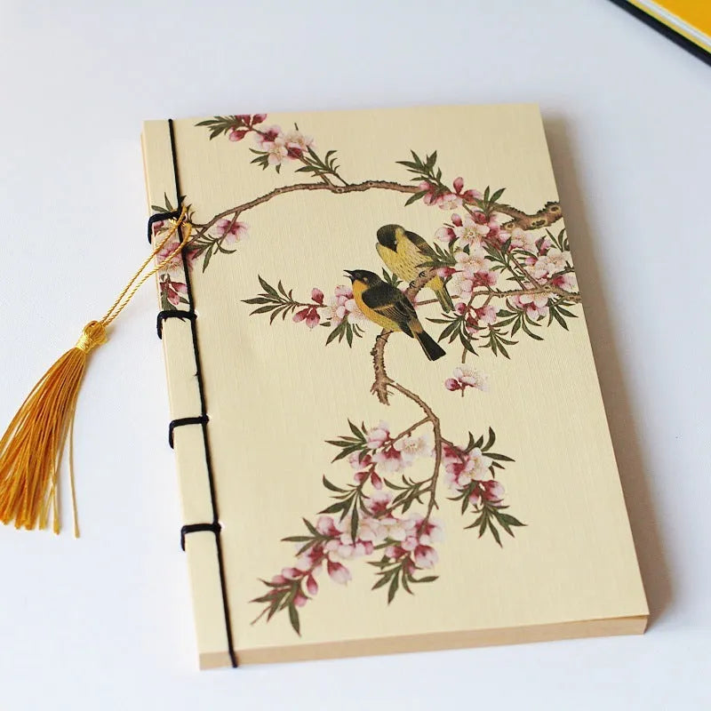 Antique wire-bound notebook with historical artwork cover and decorative tassels