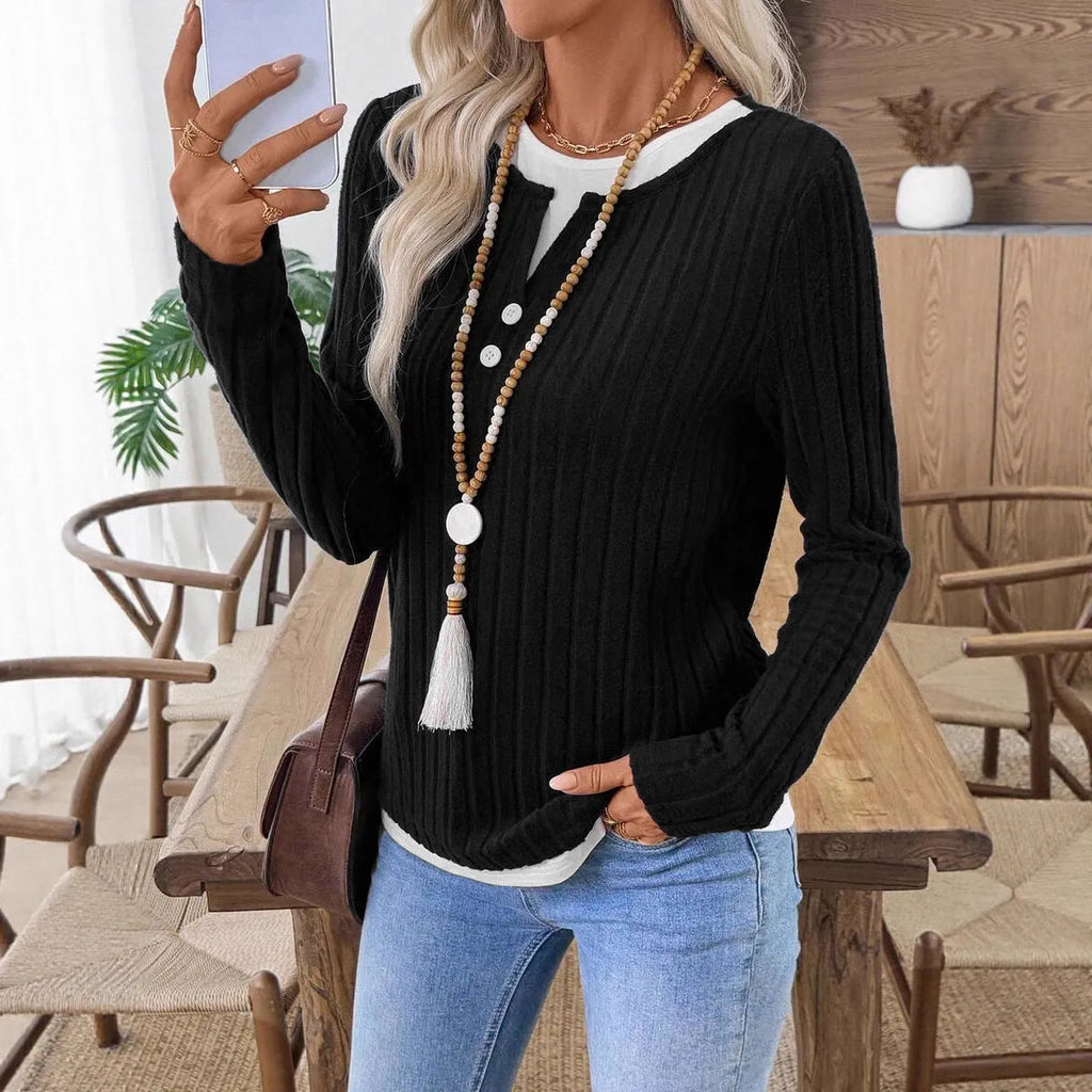 Women's black fake two-piece pullover sweater with round neck, button, and long sleeves on a hanger.