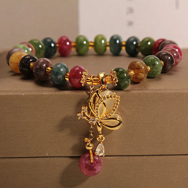 Women's colourful bracelet with alloy butterfly charm and tourmaline beads on wrist.