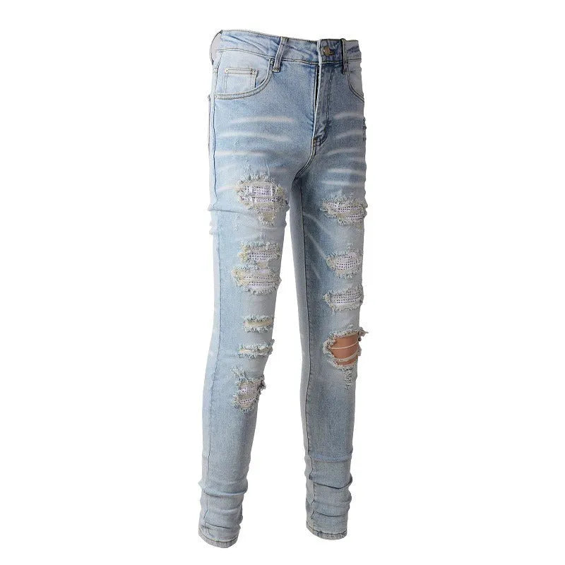 Light blue slim fit men's jeans with patch details, holes, and enzyme-washed finish