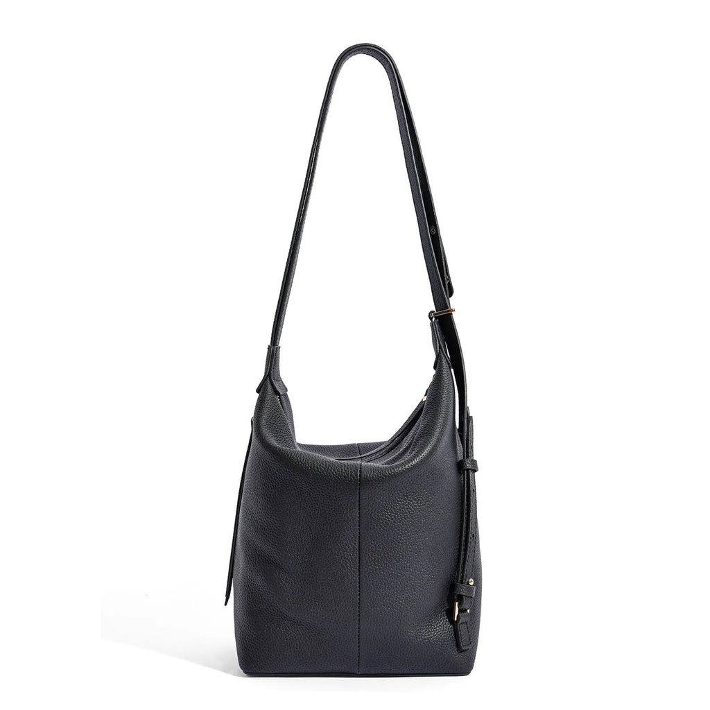 Women's large grey genuine leather bucket bag with a soft handle on a casual outfit.