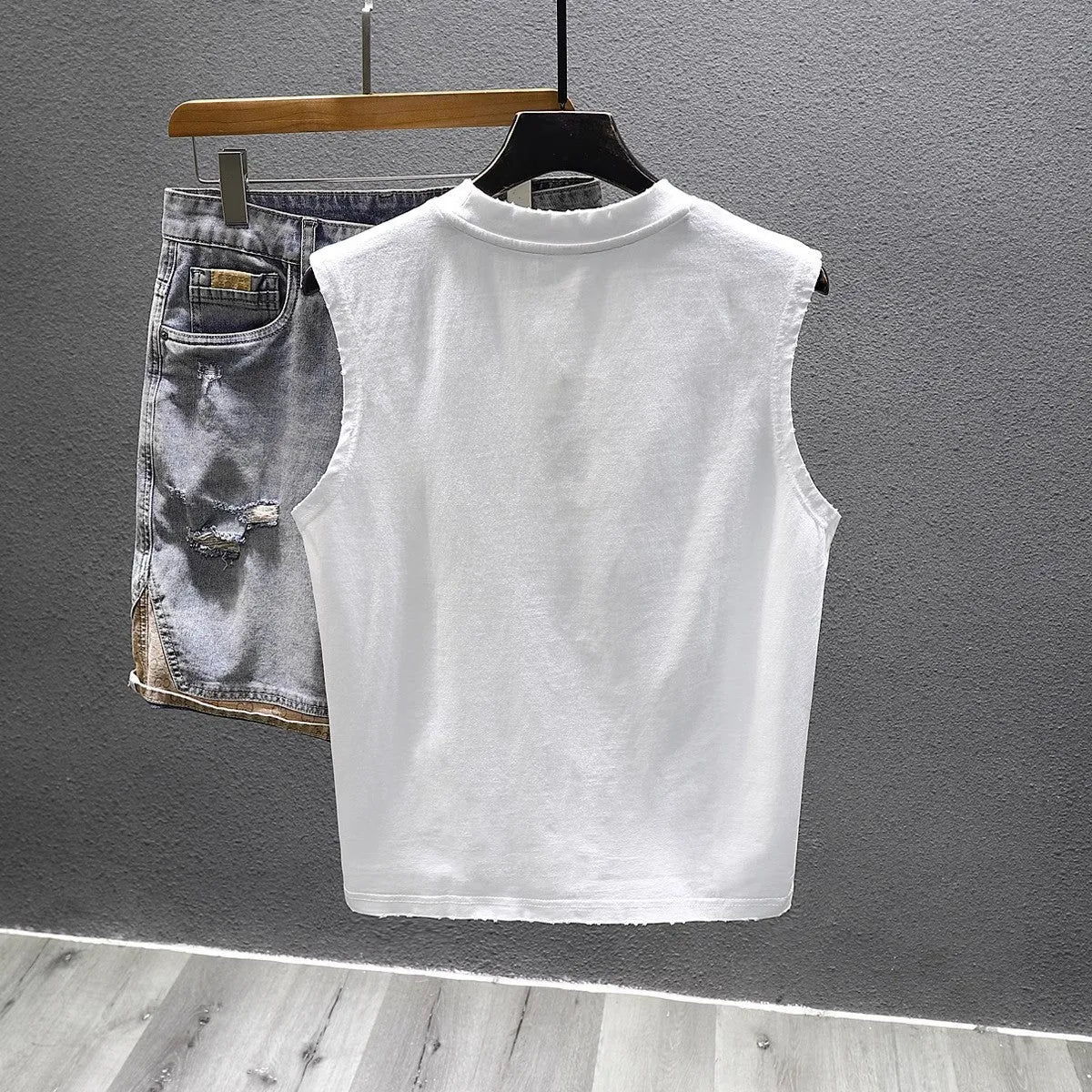 Women's loose fit cotton sleeveless vest in white on a hanger, showing straight hem and solid colour.