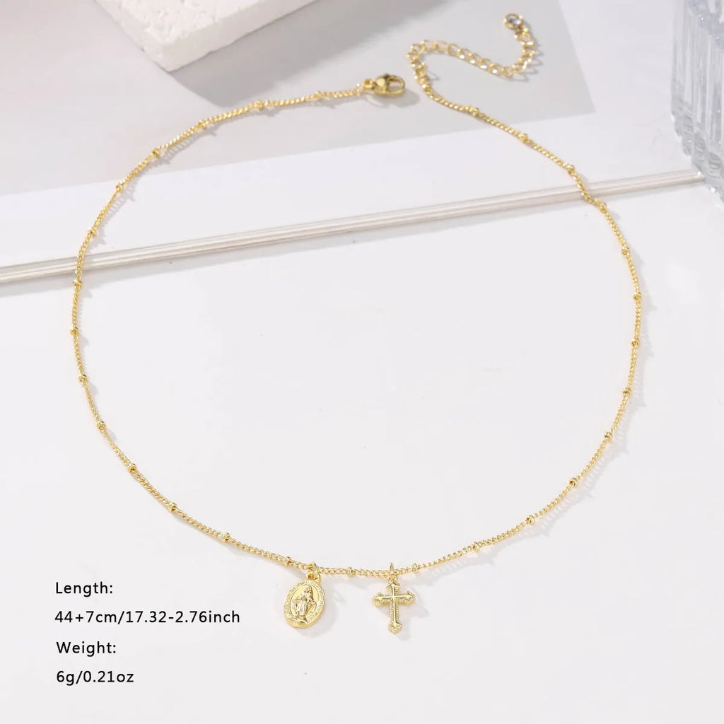 Gold geometric cross necklace with Virgin Mary detail on a 60cm chain, pendant is 3cm tall.