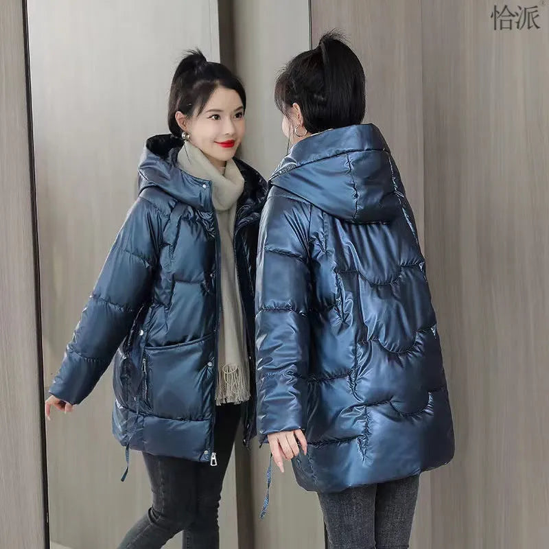 Women's green ultra-thin hooded winter jacket with long sleeves on a hanger.