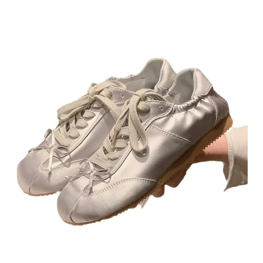 Women's silver grey satin ballet flat shoes with front lace-up design and round toe.
