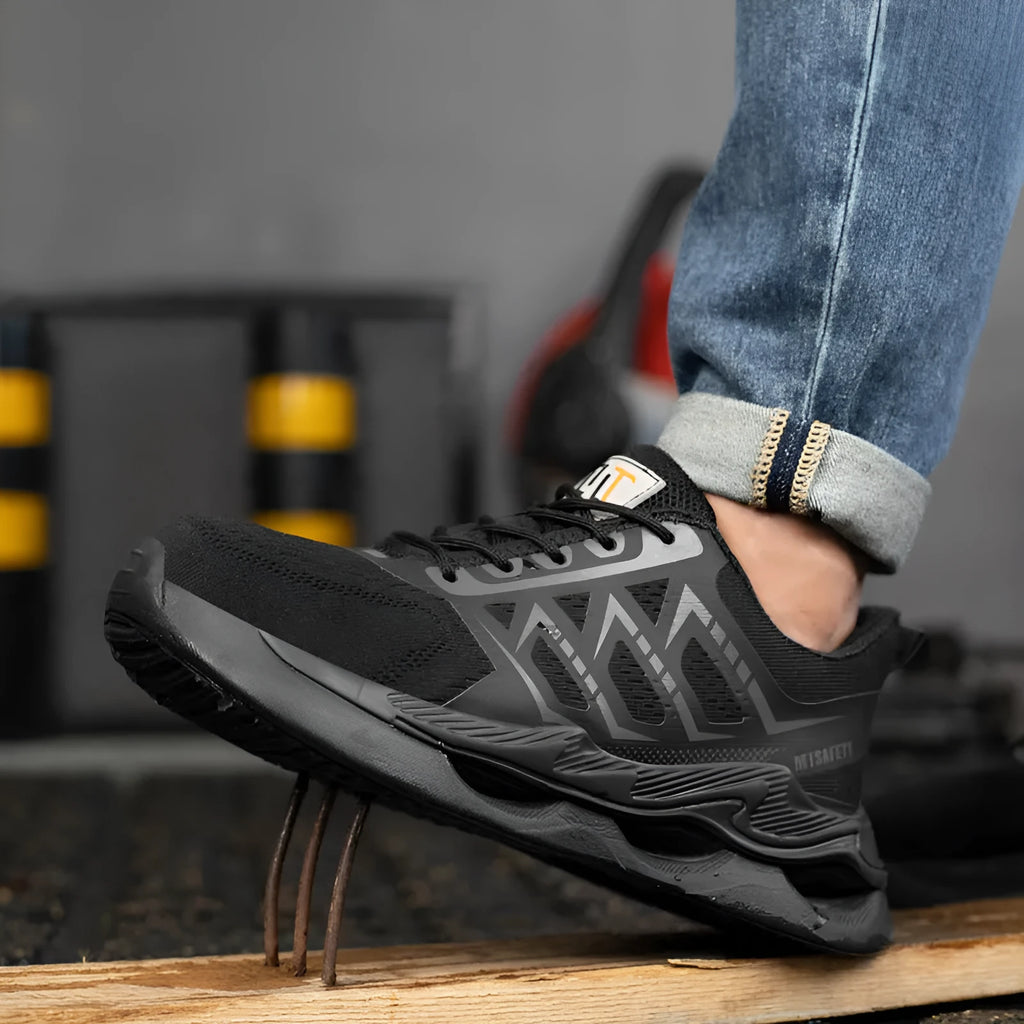 Black low-top steel toe cap safety work shoes with flat knitted uppers and lace-up front.