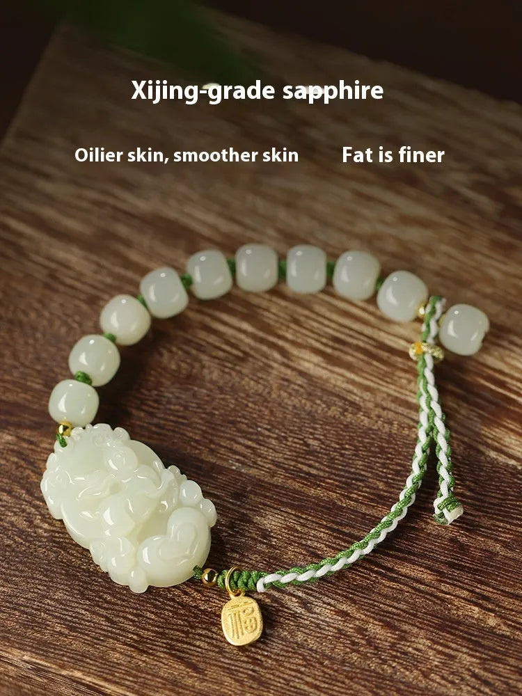 Red rope bracelet with a carved green Hetian jade Rabbit charm and a small S925 silver card on a cotton cord.