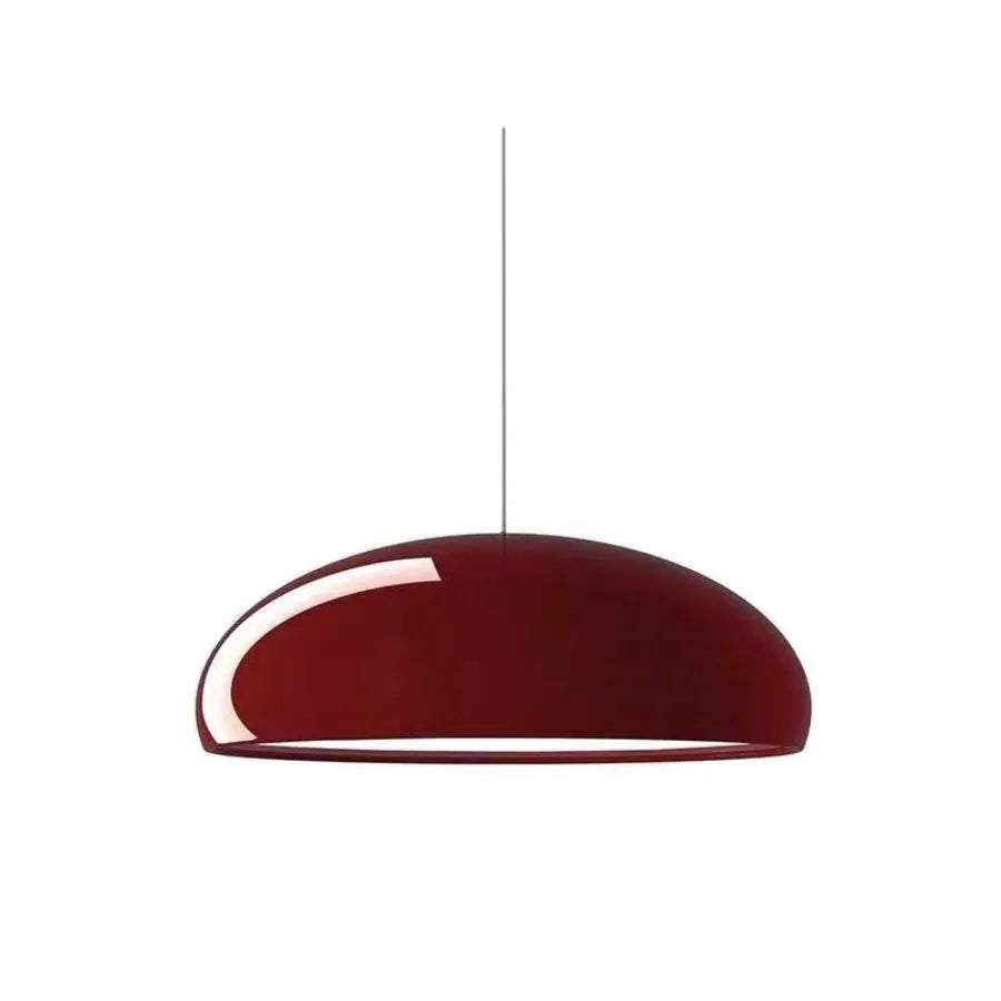 Danish-style iron pendant lamp with adjustable cord above a restaurant table.