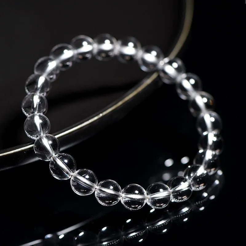 Natural white crystal bead bracelet with geometric design on a wrist.