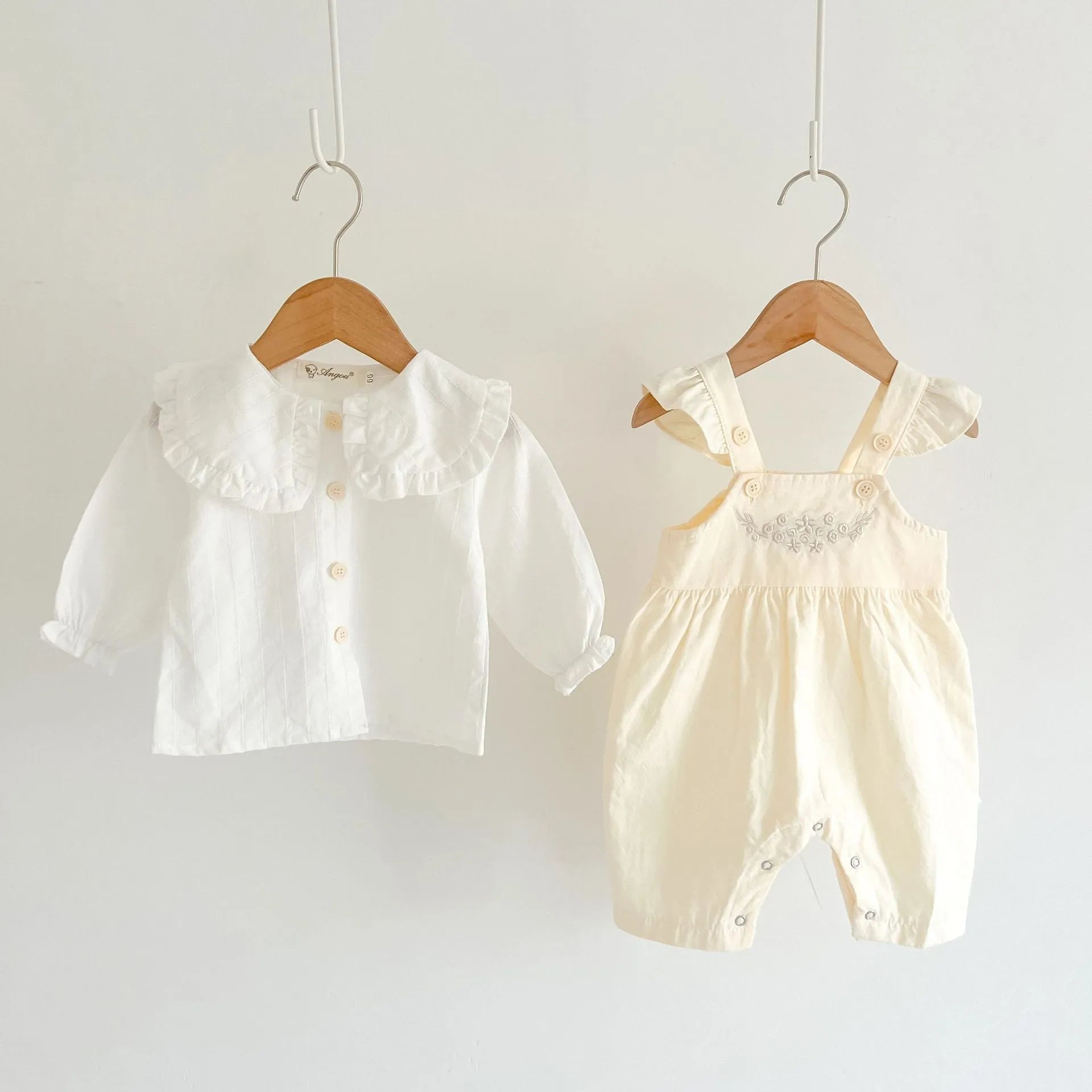 Apricot coloured baby girl's cotton romper with white top, adjustable suspenders, and mid-waist trousers.
