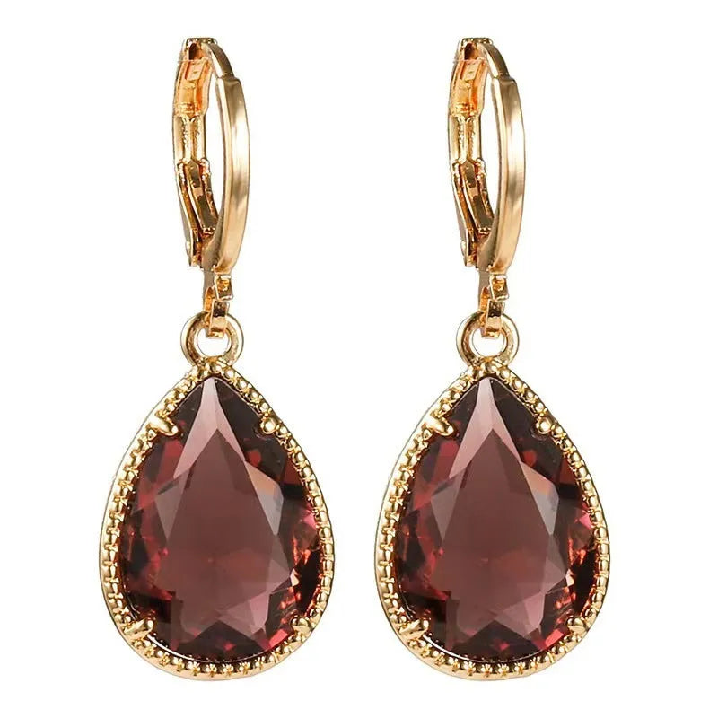 Copper-coloured rare earth metal and glass geometric saturn water drop earrings in multiple colours.