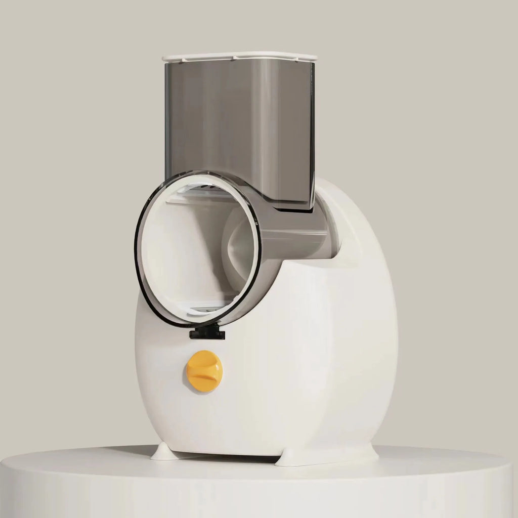 White electric vegetable slicer with suction base, feeding port, pressing rod, and multiple blades on a kitchen counter.