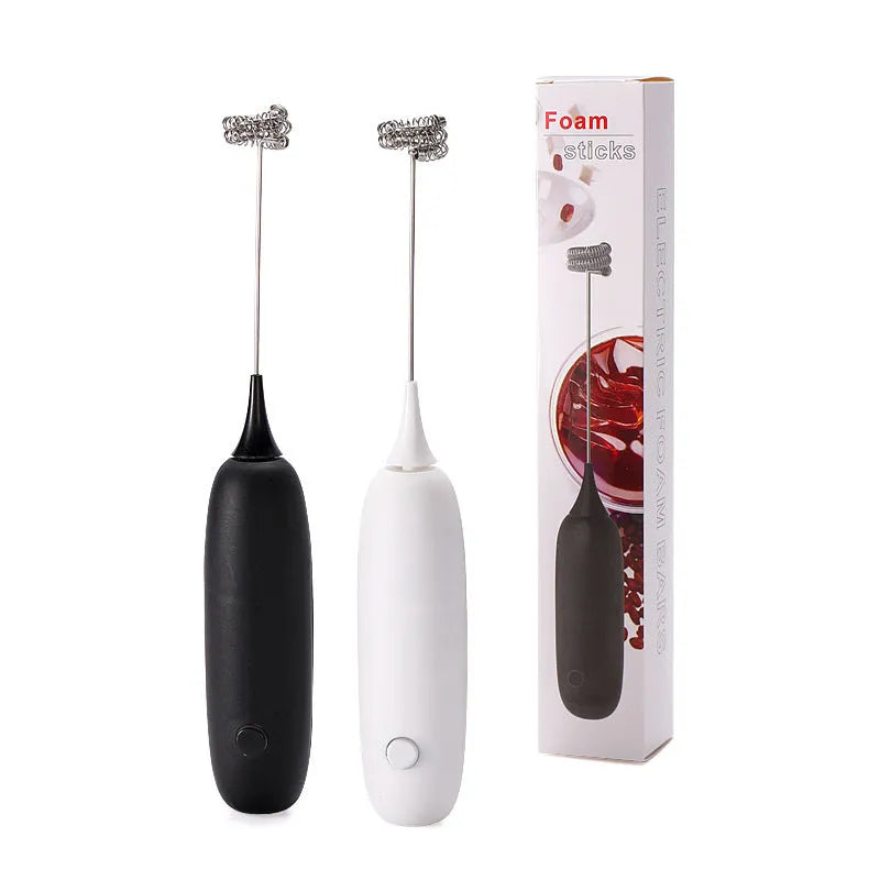 Black and white hand-held electric milk frother and blender on a kitchen counter.