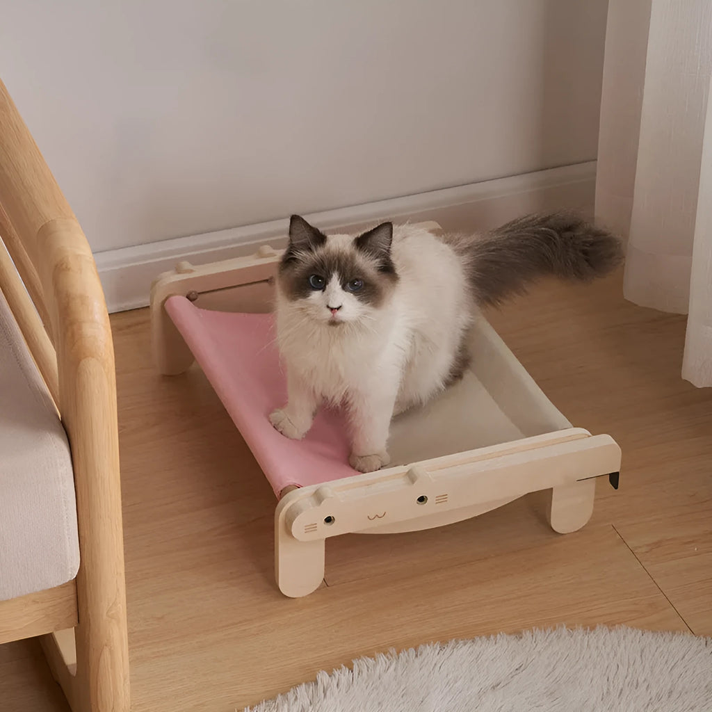 Solid wood cat bed with a removable fabric cover in a grey pink colour.