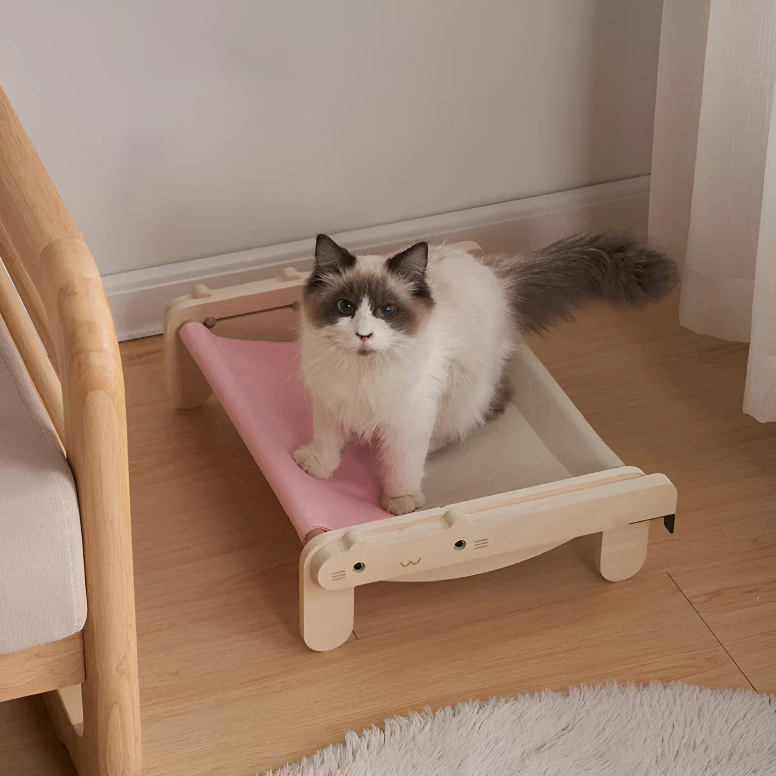 Solid wood cat bed with a removable fabric cover in a grey pink colour.