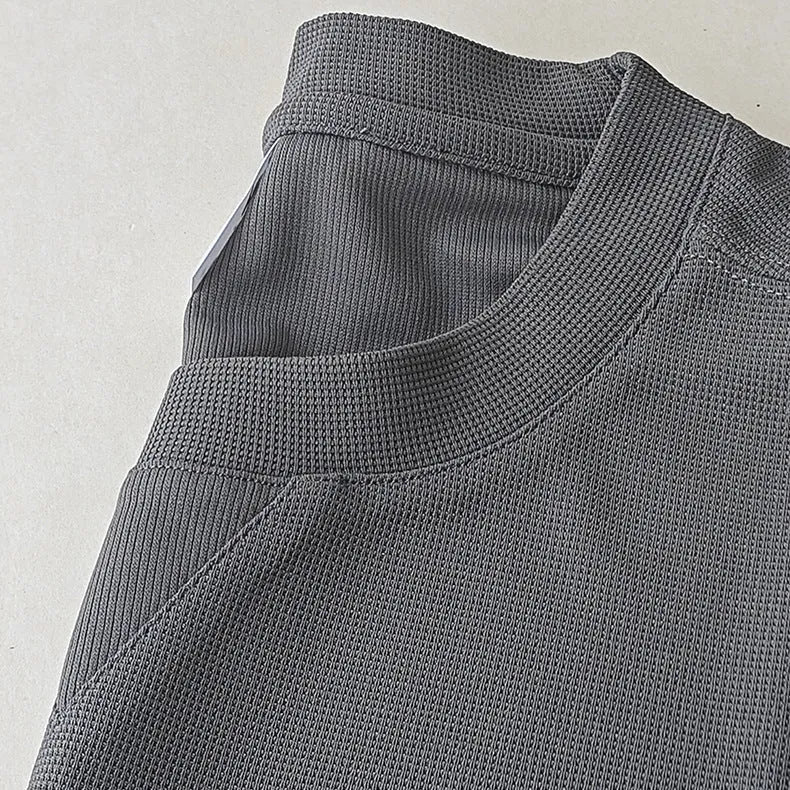 Men's heavyweight waffle-knit short-sleeve t-shirt in a solid colour on a size chart background.
