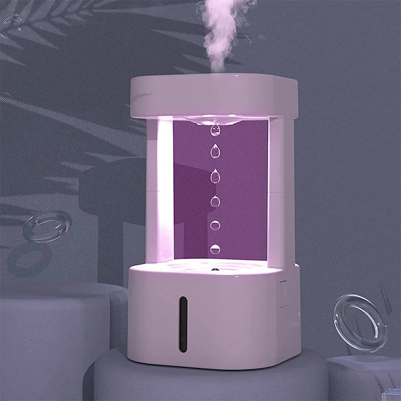 White anti-gravity water drop humidifier with coloured light on a desk next to USB cable