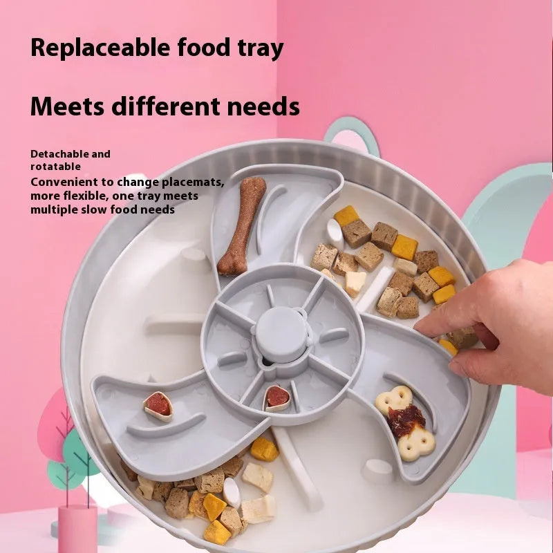 Grey pet bowl with a rotating windmill-pattern silicone licking mat for slow feeding on a kitchen floor.